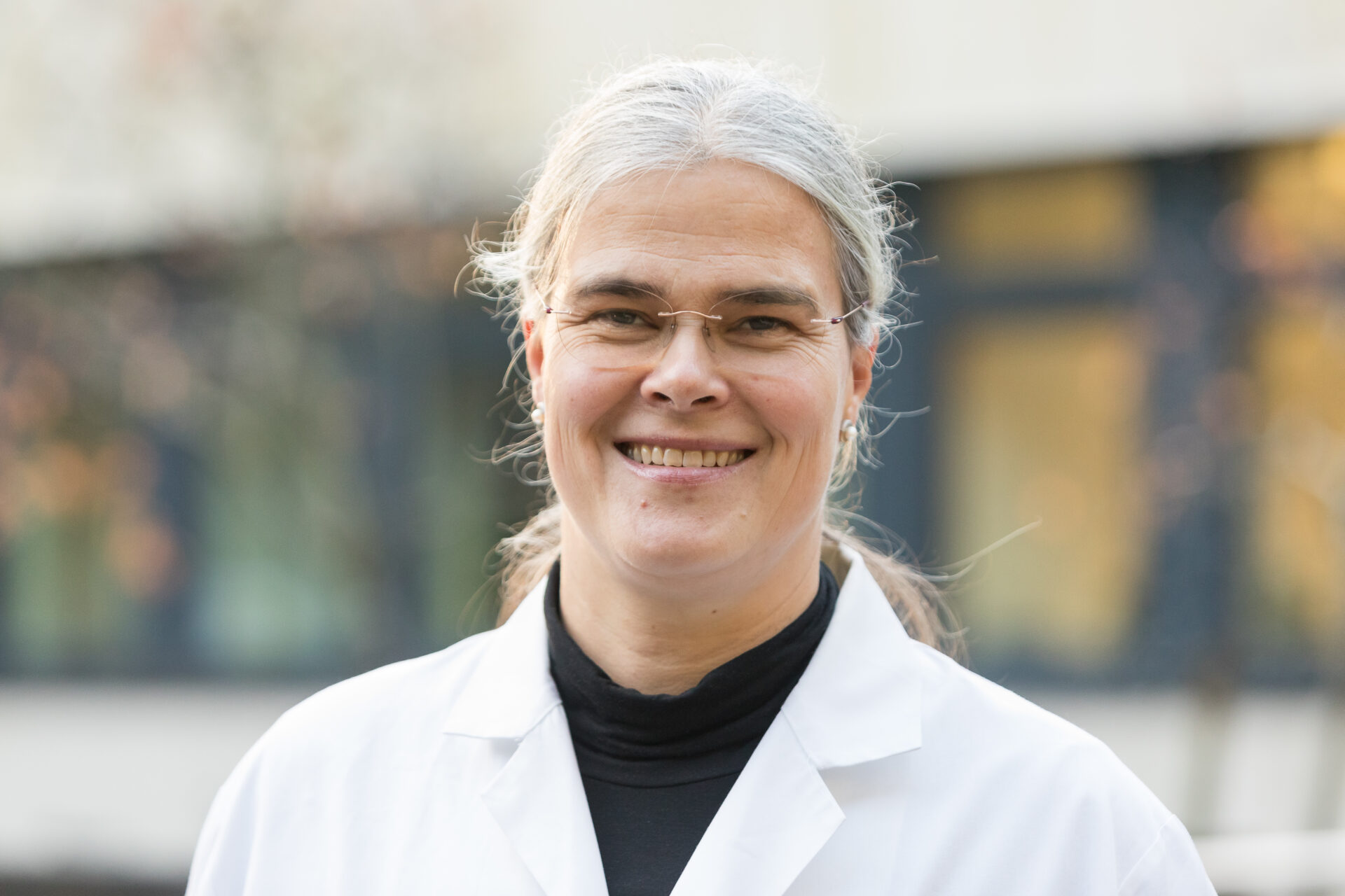 Porträt der lächelnden Ärztin Maike Baier in weißem Arztkittel.