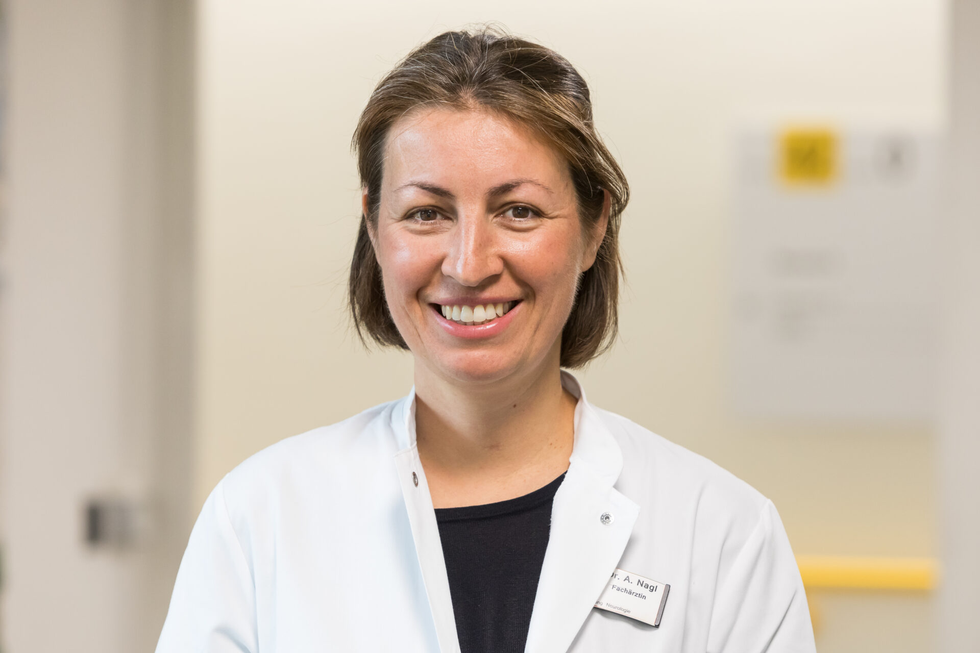 Porträt der lächelnden Ärztin Alexandra Nagl in weißem Arztkittel.