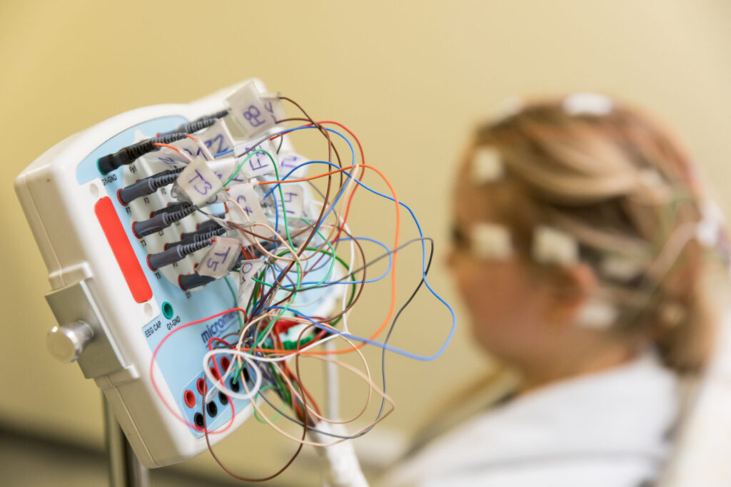 Nahaufnahme eines EEG-Geräts mit bunten Kabeln zur Messung der Gehirnaktivität.
